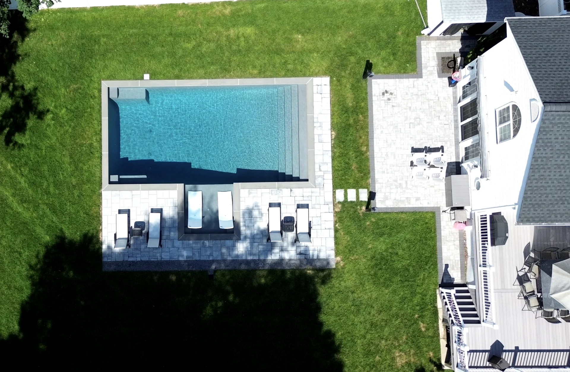 A aerial view of an outdoor pool and patio.