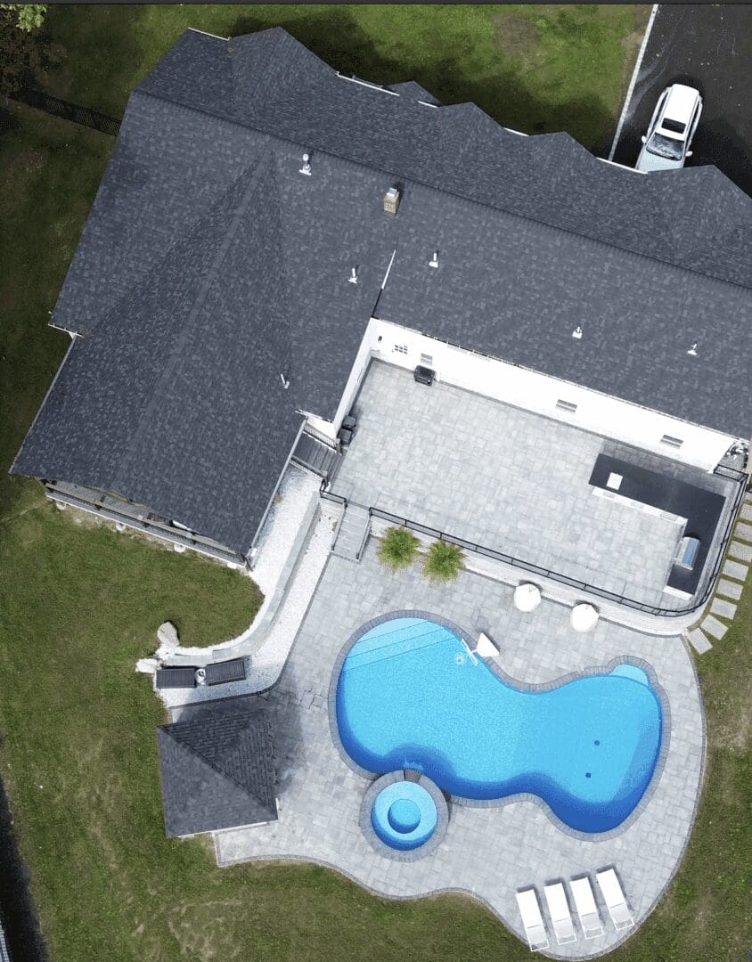 Aerial view of house with kidney-shaped pool