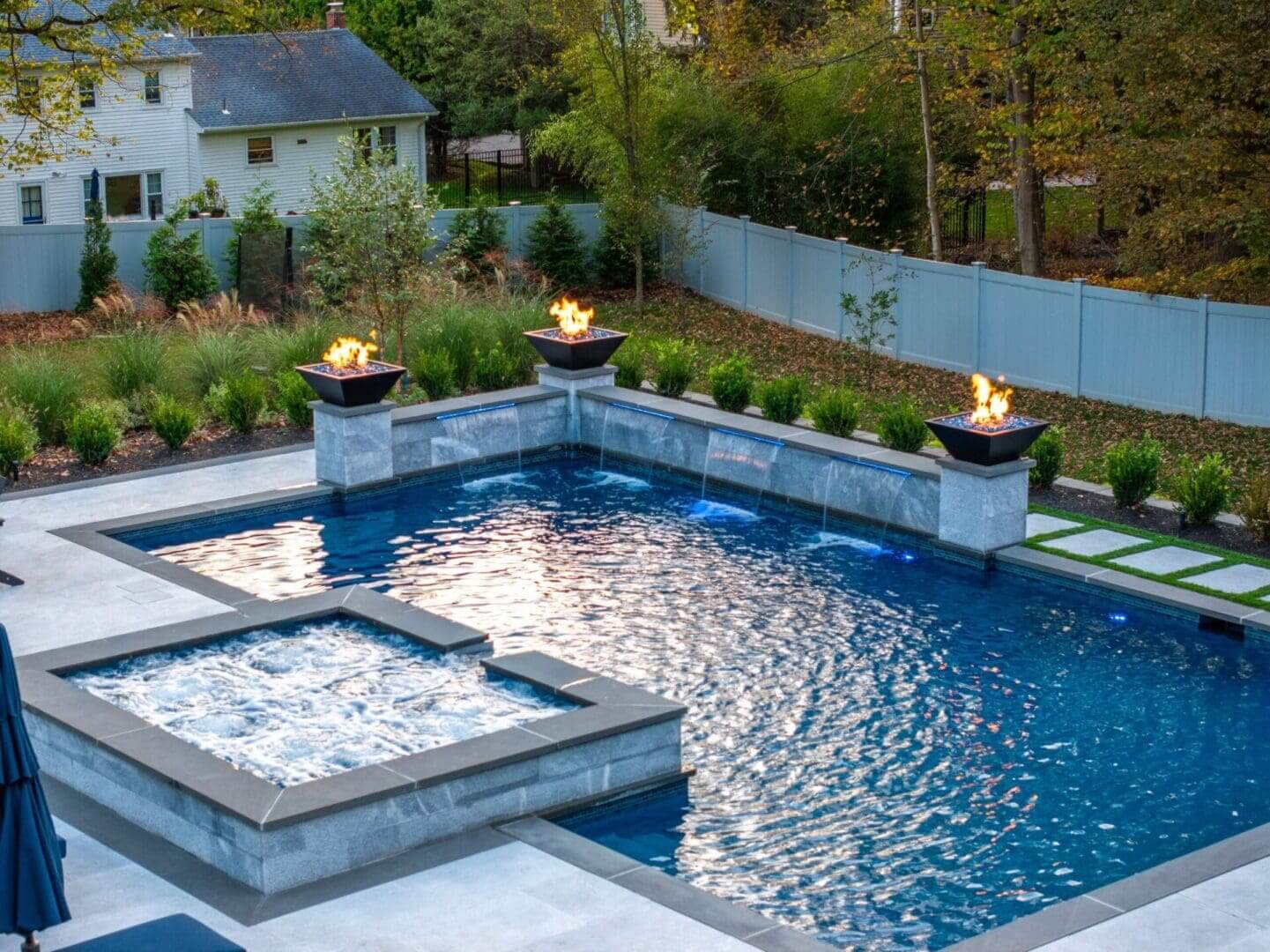 Modern backyard pool with spa and fire features